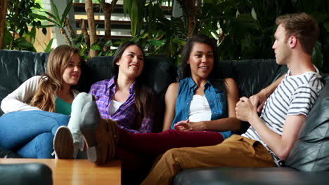 amigos felices sentados en el sofá hablando