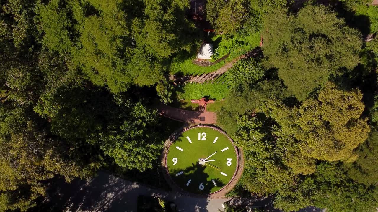 un reloj gigante en la pagoda de wat phnom rodeado de exuberante vegetación y senderos tranquilos
