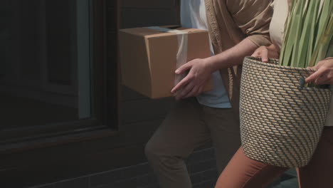 couple carrying belongings and moving house