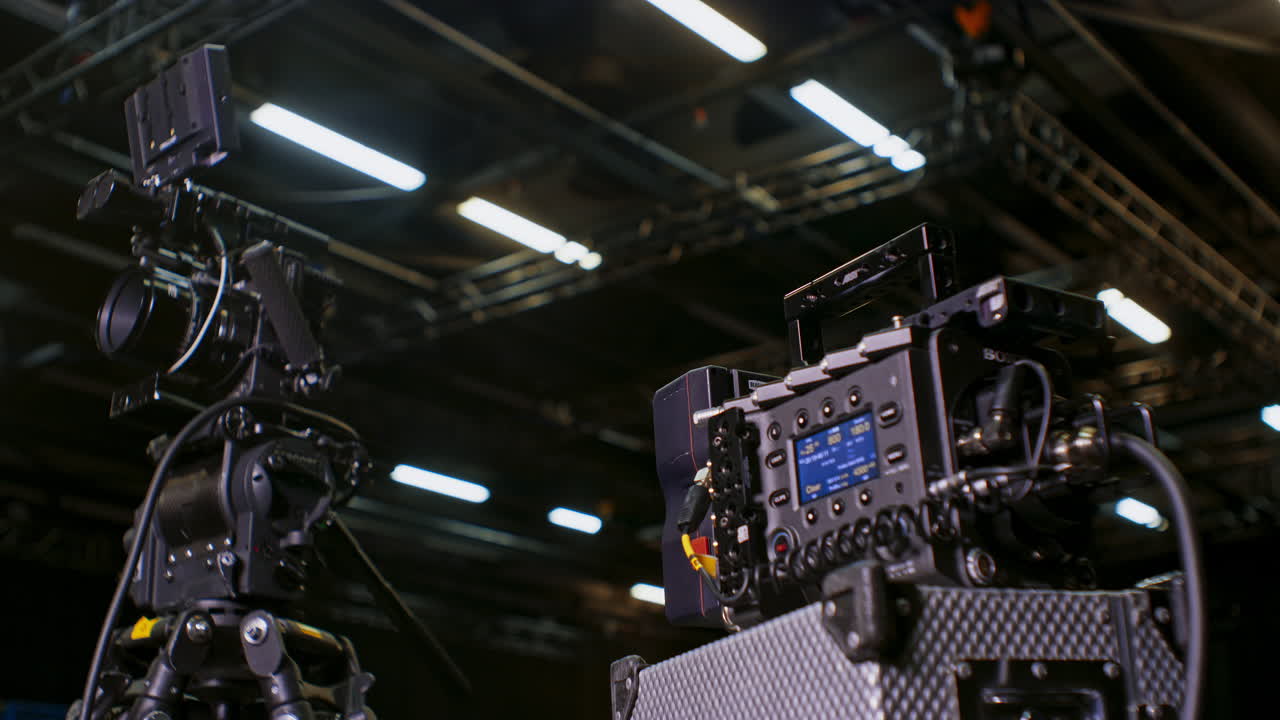 профессиональная высококлассная кинокамера с отделенным блоком датчиков и установленной на штатив и главой с жидкостью с аксессуарами