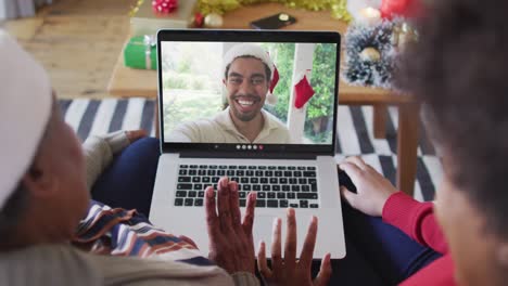 Afroamerikanische-Mutter-Und-Tochter-Nutzen-Laptop-Für-Weihnachtsvideoanruf-Mit-Mann-Auf-Dem-Bildschirm