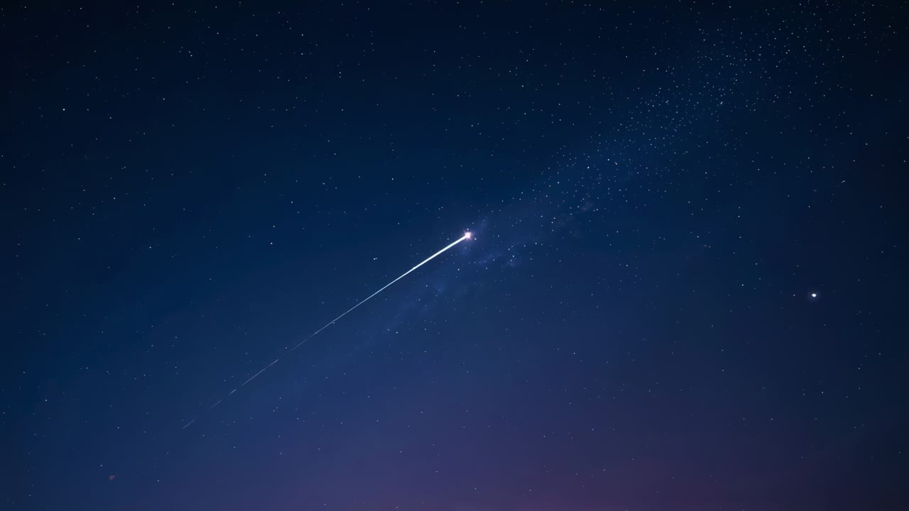 Shooting meteor entering air racing across night above horizon, with trail among stars, copy space