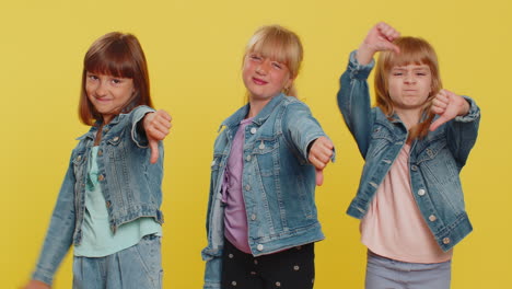 three girls siblings friends showing thumbs down sign gesture, disapproval, dissatisfied, dislike