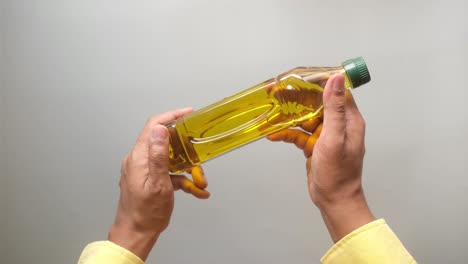 person holding a bottle of oil