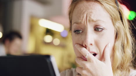 woman looking distressed at a tablet