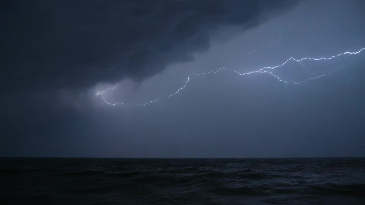 Flashing right spark starting low cloud over ocean sending branched lightning lighting waves