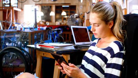 woman using digital tablet at workshop 4k