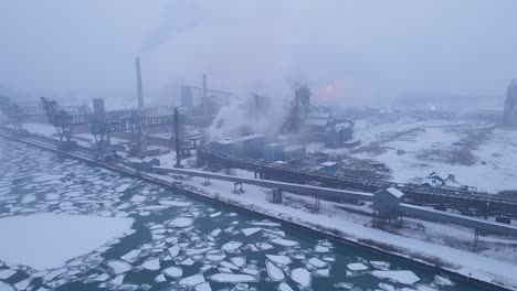 zug island steel plant industry in fog with smoke and icy river in detroit, usa
