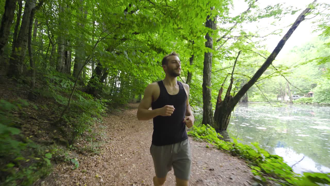 un joven feliz corriendo en el bosque.