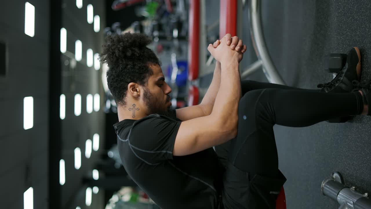 el hombre sentado y respirando después de terminar el curso de entrenamiento con pesas en el gimnasio