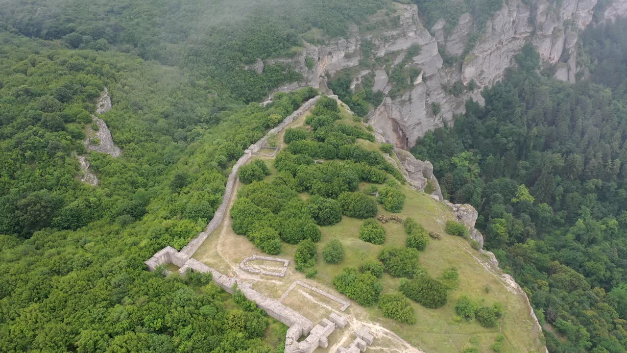 Luftaufnahme einer alten Festung Madara mit von den Seiten heranziehenden Wolken.