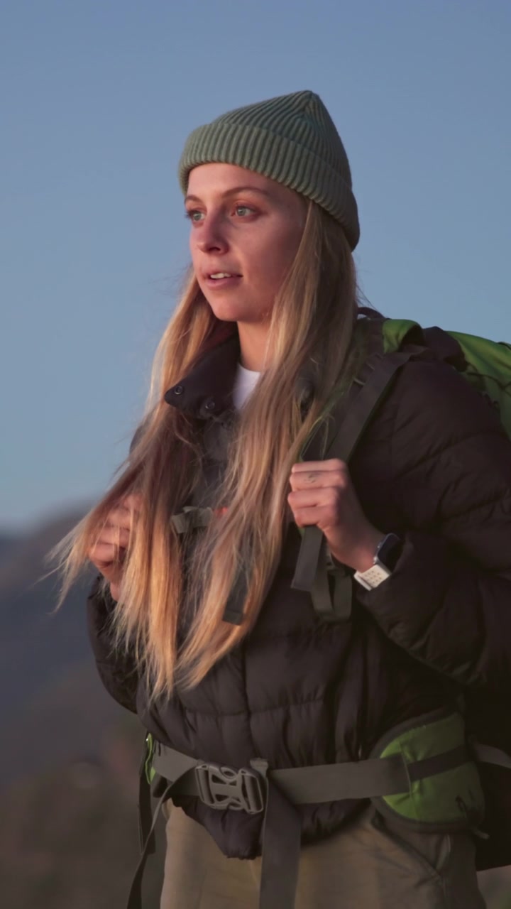 Giovane escursionista donna che fa un respiro profondo sulla cima di una montagna