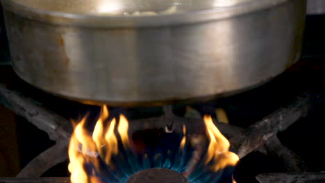 una toma en cámara lenta de cerca de la pasta que se arroja en una sartén sobre el fuego