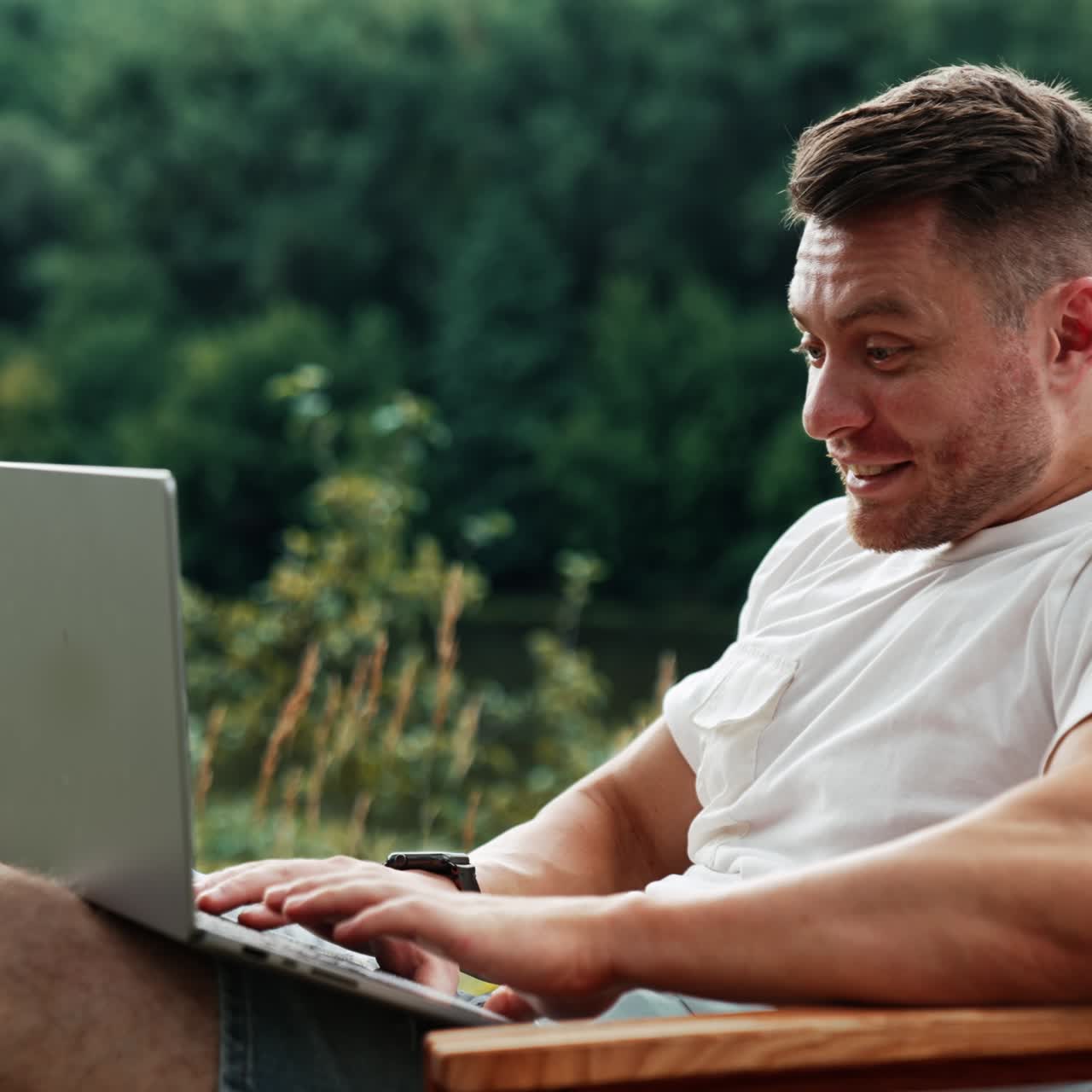 Caucasian man seems to be surprised looking at the screen of his laptop. Freelancer work remote in the nature on computer