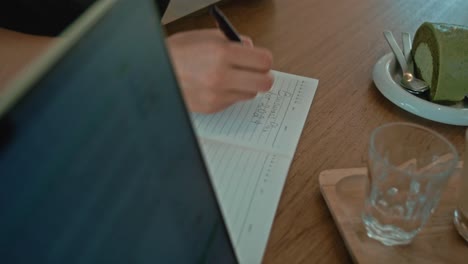 person writing a business plan in a coffee shop