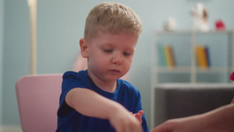 little child concentratedly takes seeds from palm
