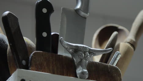 Pan-right-of-knife-block-with-menacing-arrangement-of-knives-and-metal-bull-head