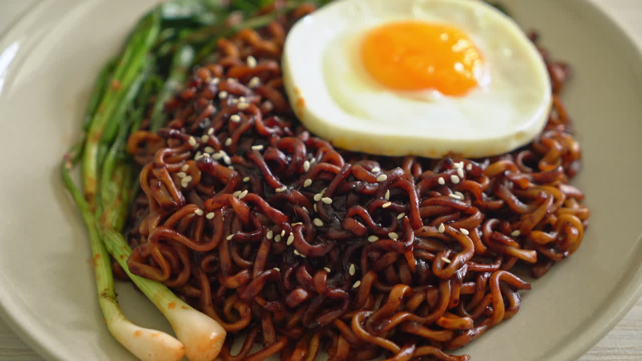 fideos instantáneos secos caseros con salsa negra picante coreana con huevo frito y kimchi