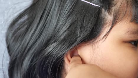 close-up of a child touching her ear