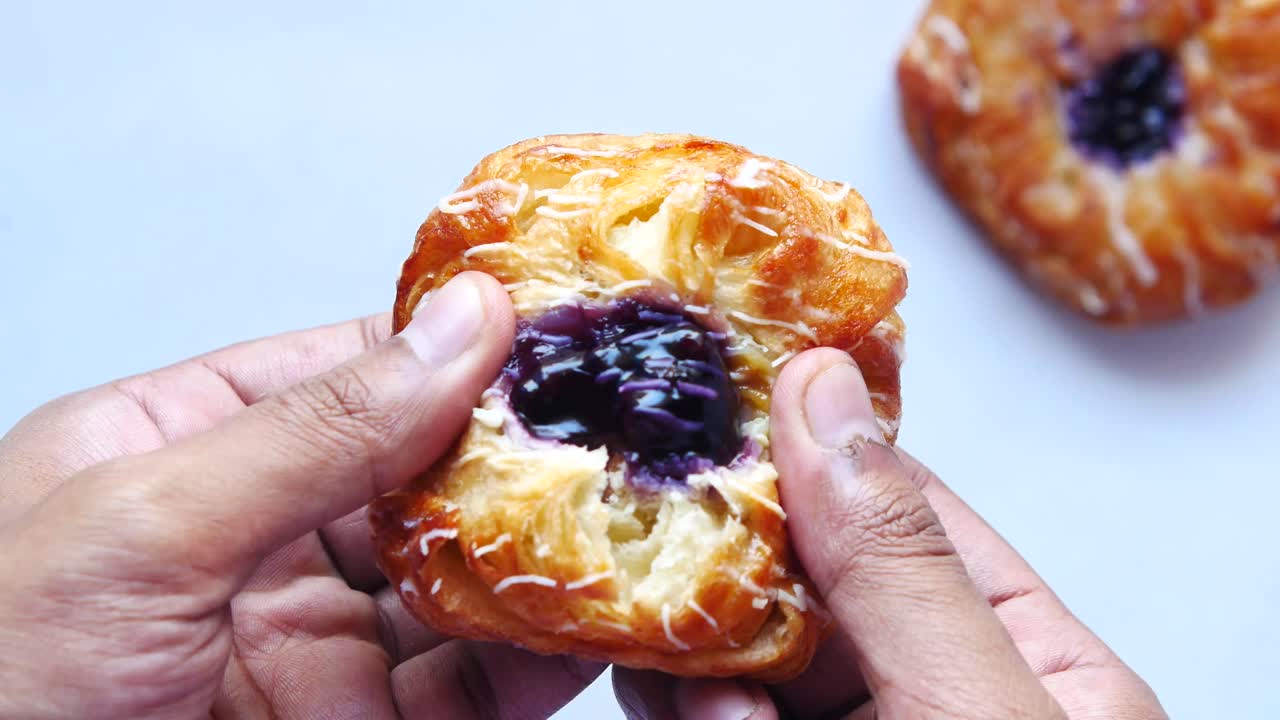 블루베리 덴마크 페이스트리를 들고 있는 손