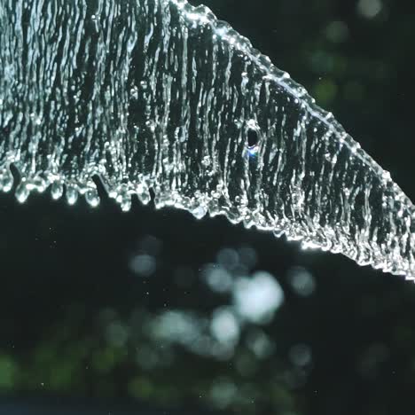stream of water spraying from garden hose, close up. watering the green grass. slow motion.