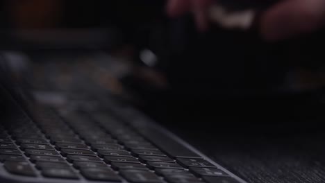 Hand-typing-on-a-black-computer-keyboard,-close-up-side-view