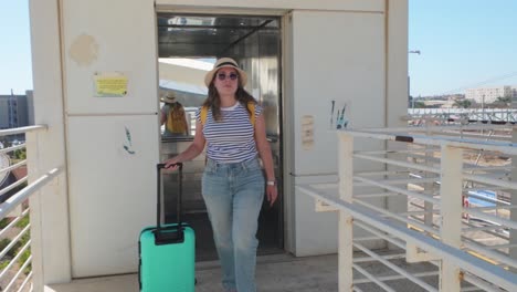 the tourist steps out of the elevator confidently, wearing a backpack and summer hat.