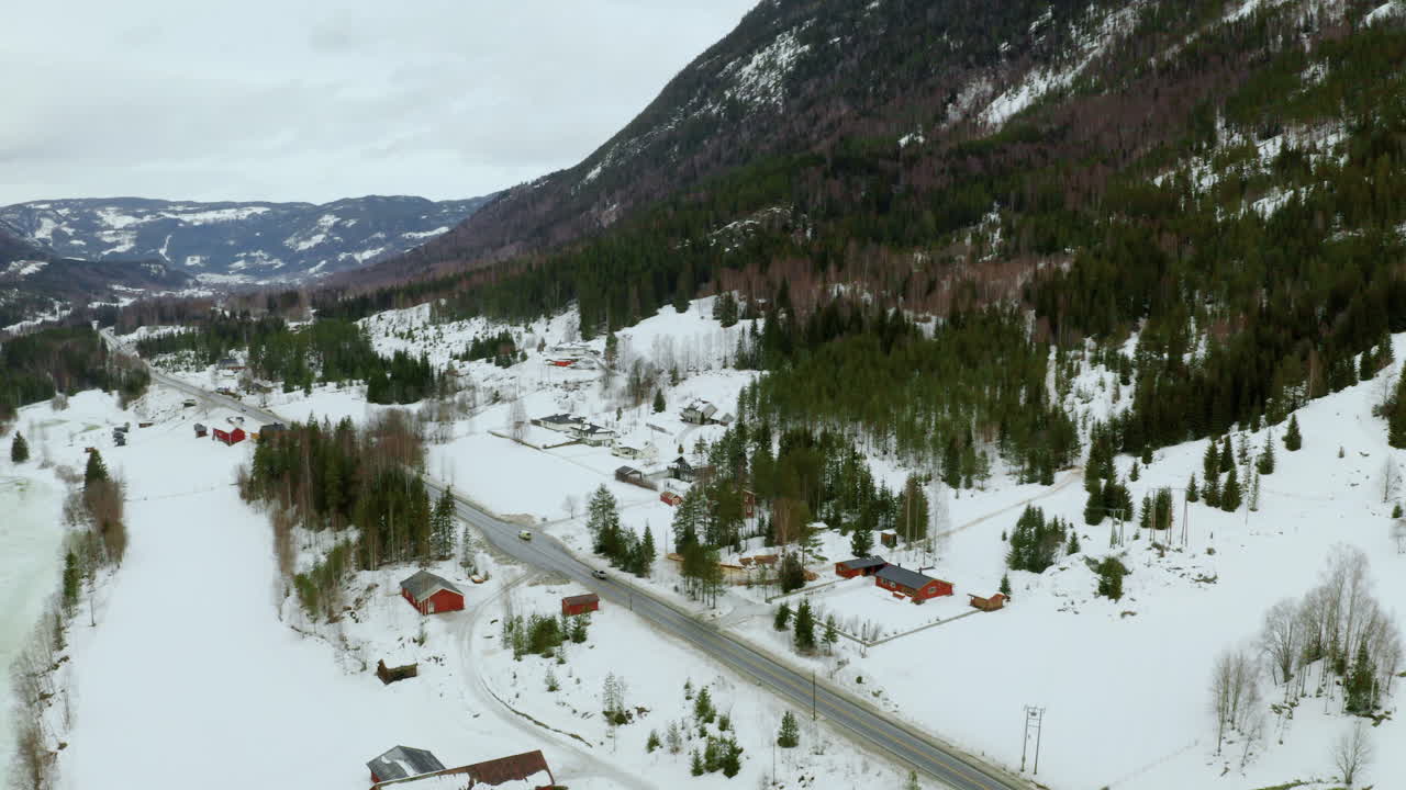 nieve gruesa que cubre el pie de la montaña en un pequeño pueblo en haugastol noruega - toma aérea amplia