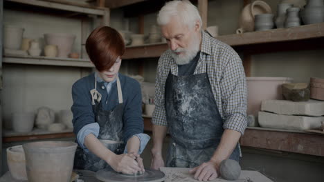 grandfather and grandson learning pottery together