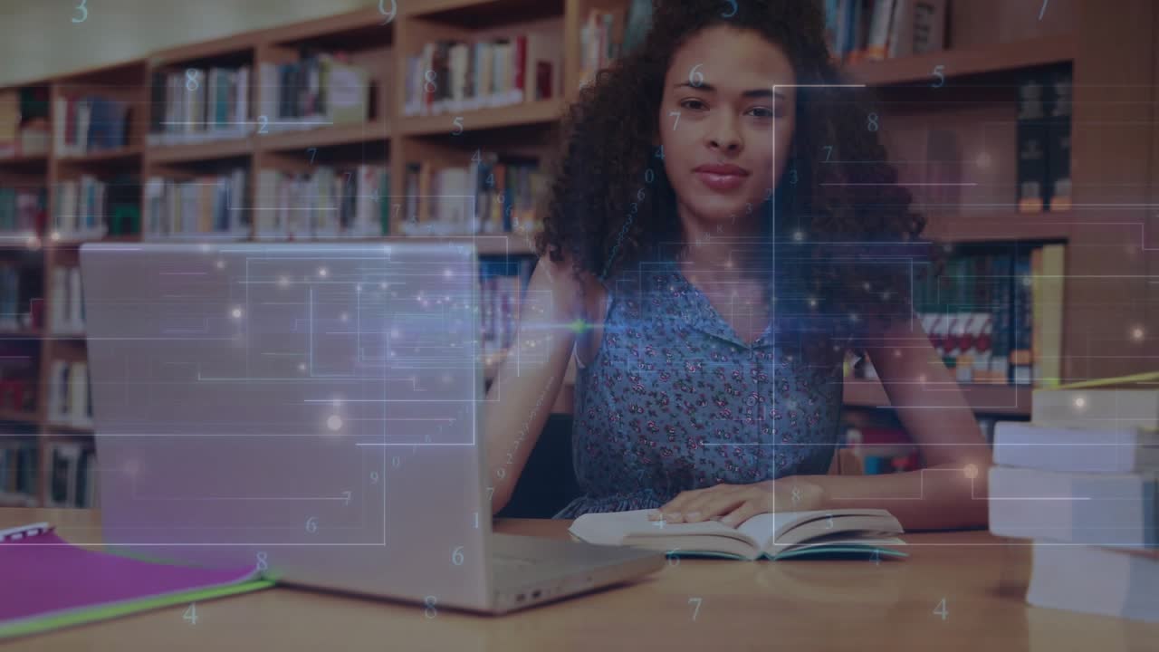 Female student sitting library table, turning pages, glancing at silver laptop, researching