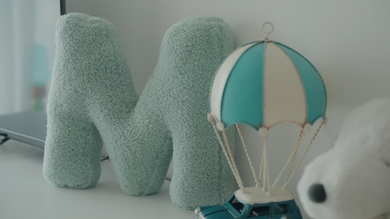 Cute pastel nursery decor with plush letter pillow and toy balloon