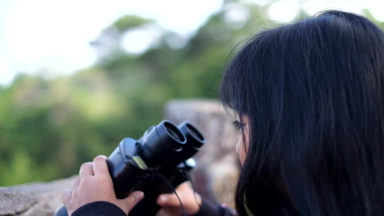 Child looking through binoculars on a mountain in Baguio, Philippines