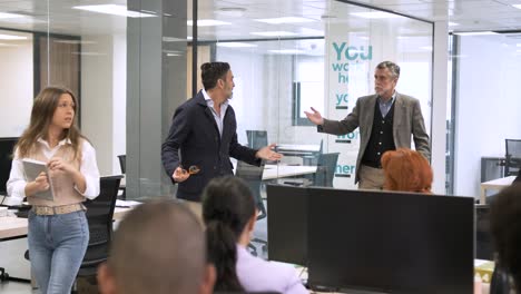 Businessman scolding female employee in creative office