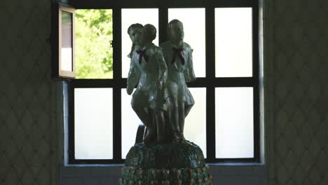 porcelain statue of soviet children pioneers, open window behind