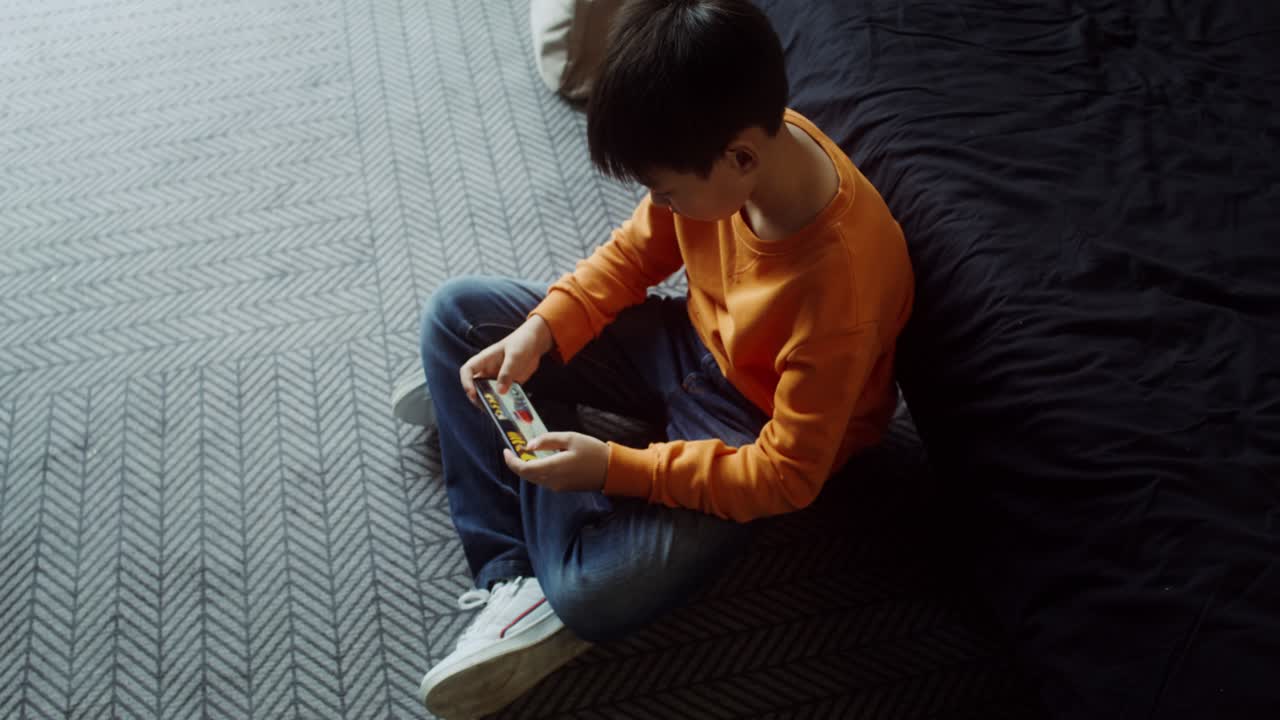 Boy Using Smartphone in Bedroom