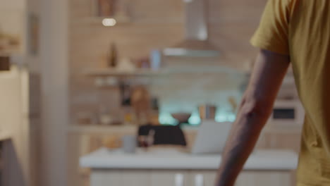 man using smartphone with smart home security app turning on the lights