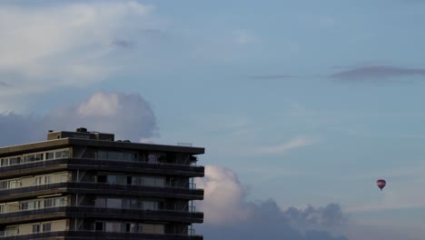 edificio de apartamentos de amberes con globo de aire caliente en la distancia, lapso de tiempo