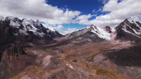 aerial view of one of the 7 lagoons of ausangate, cusco, peru, with snow-capped peaks, reverse dolly