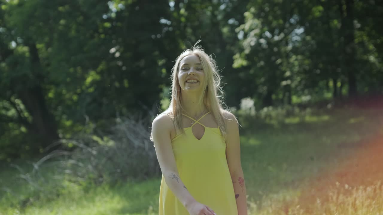 mujer con vestido amarillo bailando con gracia en el parque de verano