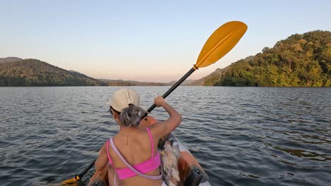 person kayaking on a lake with mountain views