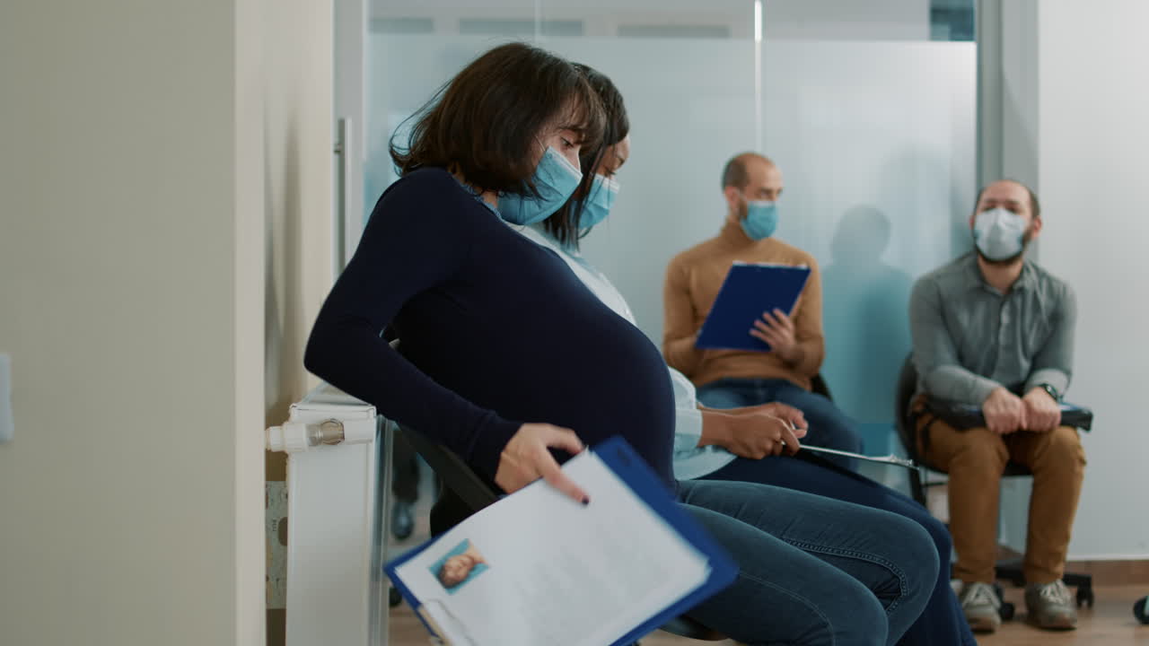 Candidata incinta che tiene in mano dei documenti e si prepara per un colloquio di lavoro