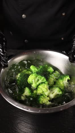 chef preparing broccoli in ice water