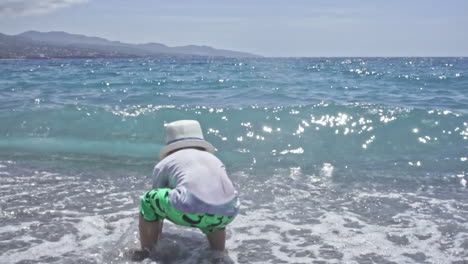 three years old child enjoys the sea at kalamata beach greece slow motion