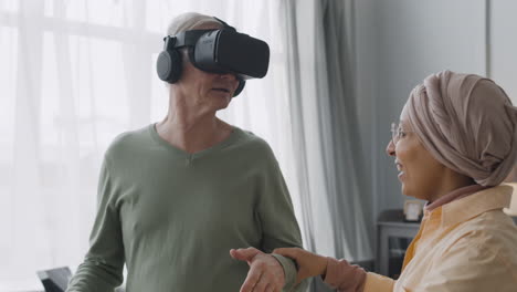 middle aged arabic woman helping a happy senior man to use virtual reality headset glasses at home