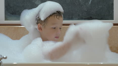 child playing with foam in the bath