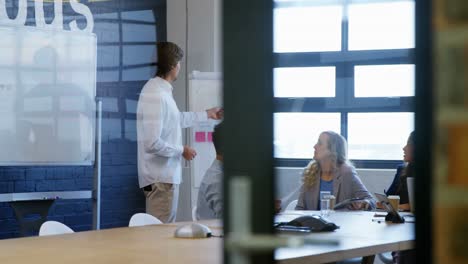 business executives discussing over whiteboard