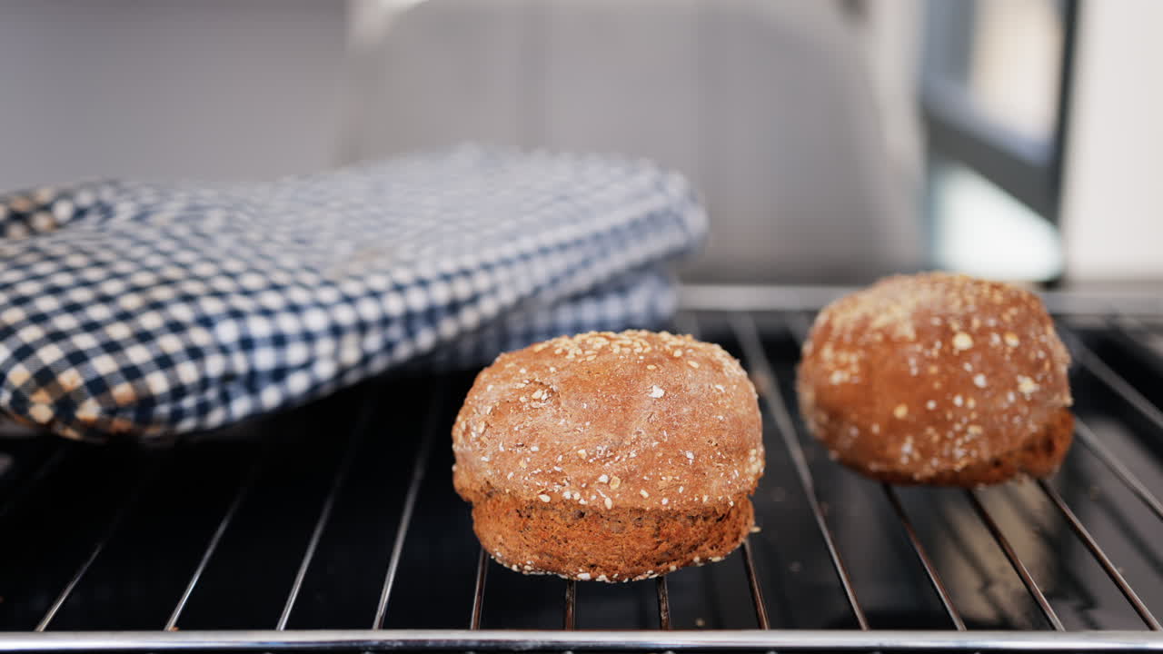 Close up of rye bread rolls on an oven grill tray