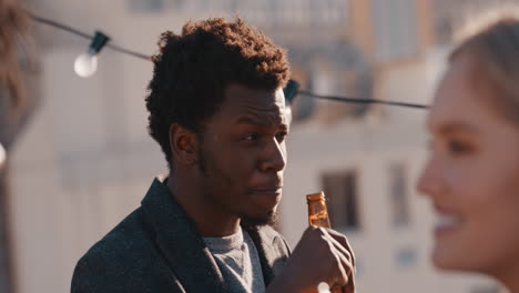 group of diverse friends hanging out together enjoying rooftop party at sunset happy african american man socializing drinking alcohol having fun on weekend celebration