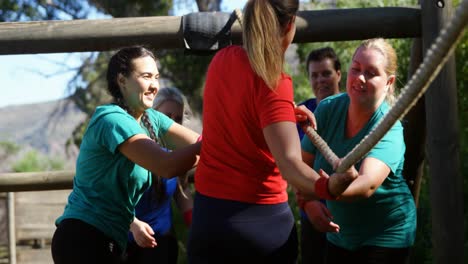 women applauding female trainer while rope climbing