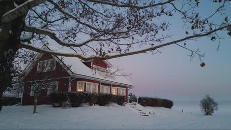 Aerial-forward-view-of-a-beautiful-scandinavian-home-in-a-snow.